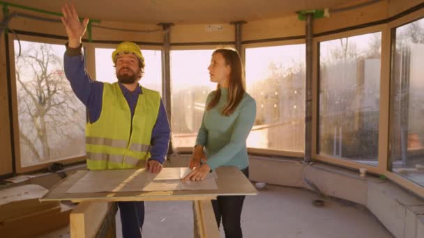 LENS FLARE Contractor and woman argue over construction plans on a sunny morning — Stock Video