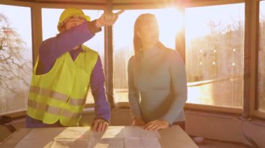 UP Sunrise, bina sahibi ve mimar olarak odayı aydınlatıyor. Kat planlarını tartışıyor.