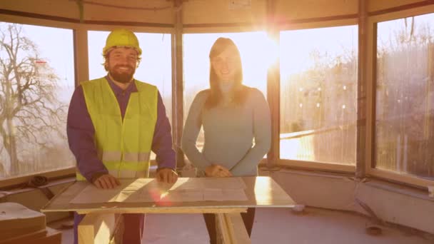 RETRATO: Arquiteto e investidor imobiliário sorriem depois de discutir planos de piso. — Vídeo de Stock
