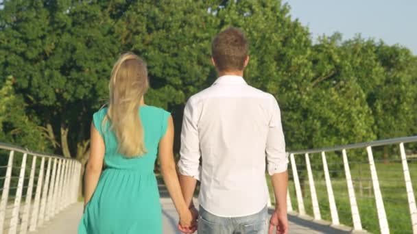 Yaklaş. Tanımlanamayan adam ve aşık kadın köprüden geçerken el ele tutuşun. — Stok video