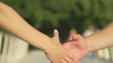 Tanımlanamayan adam ve kadın parkta karşılaştıklarında el sıkışıyorlar..