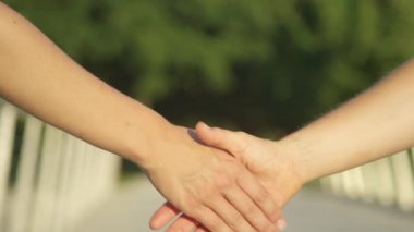 Genç iş arkadaşları parkta buluşup el sıkışarak selamlaşıyorlar..