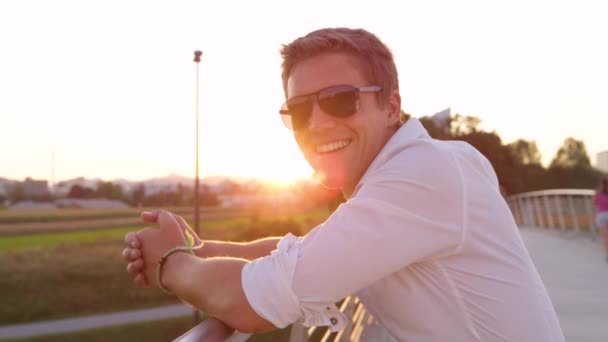 CLOSE UP: Чоловік у сонцезахисних окулярах дає великий палець на сонячний весняний ранок . — стокове відео