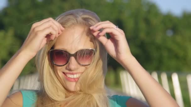 PORTRAIT : Jeune femme rit en jouant avec ses magnifiques longs cheveux blonds. — Video