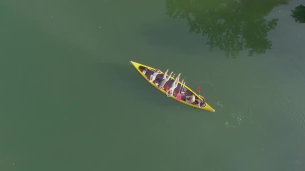 TOP DOWN: Amigos despreocupados deitados em uma costa de canoa ao longo de um rio preguiçoso na Eslovênia — Vídeo de Stock