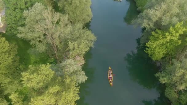 TOP DOWN: zorgeloze toeristen peddelen hun kano langs de rustige rivier Krka. — Stockvideo