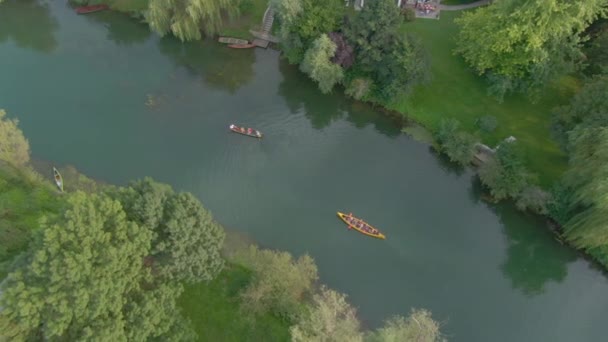 TOP DOWN: Turyści wiosłują małą łódką i kajakiem wzdłuż leniwej rzeki Krki. — Wideo stockowe