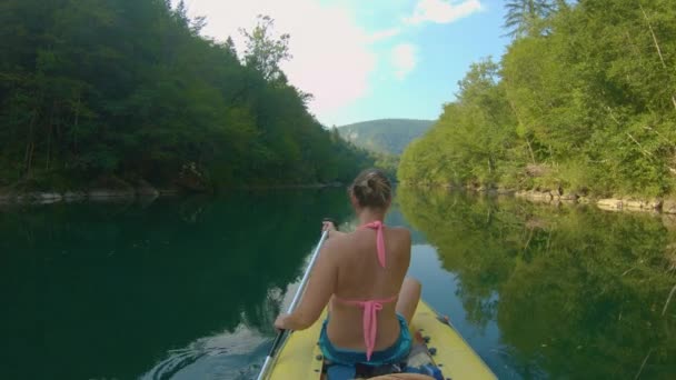 FERMER : Femme méconnaissable pagaie un radeau le long de la rivière tranquille Kolpa. — Video