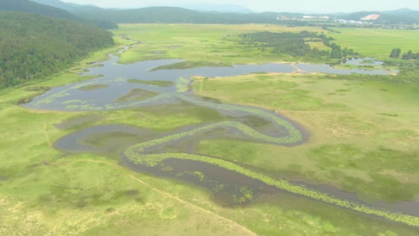 DRONE: Volando sobre prados inundados cerca de un pueblo en la campiña eslovena. — Vídeos de Stock