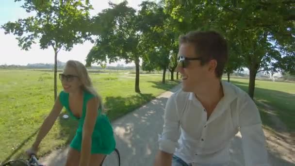 セルフィー:快適な若いカップルが風光明媚な日光の通りを自転車に乗っています. — ストック動画