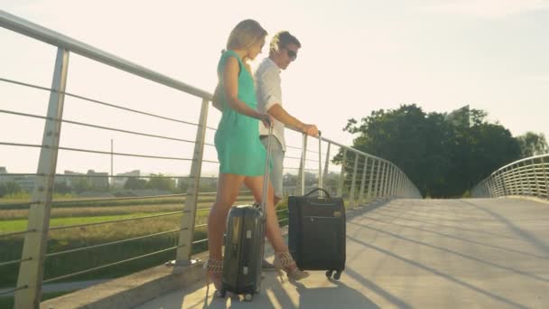 LENS FLARE: Gouden zonnestralen schijnen op pasgetrouwden beslissen om te lopen naar de luchthaven — Stockvideo