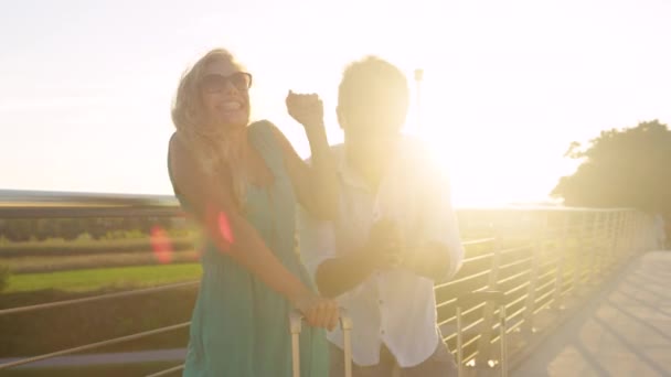 CLOSE UP Excited man drops his sunglasses while waiting for ride with girlfriend — Stock Video