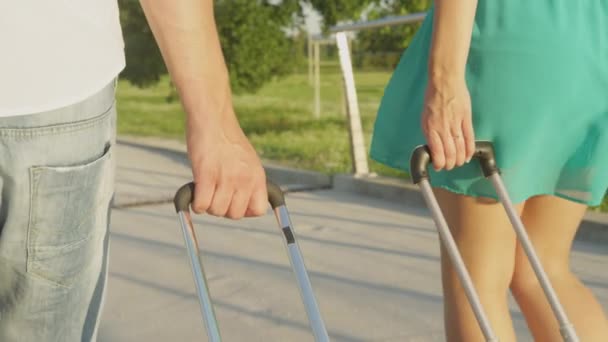 CLOSE UP: Unbekanntes Brautpaar schleppt sein Gepäck auf dem Weg zum Flughafen. — Stockvideo