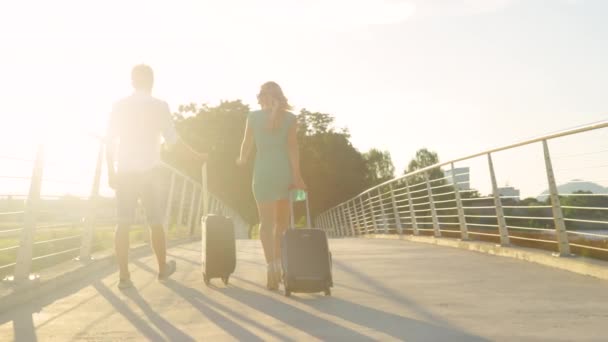 ESPACE DE COPIE : Les jeunes mariés portent leurs valises à l'aéroport au coucher du soleil. — Video