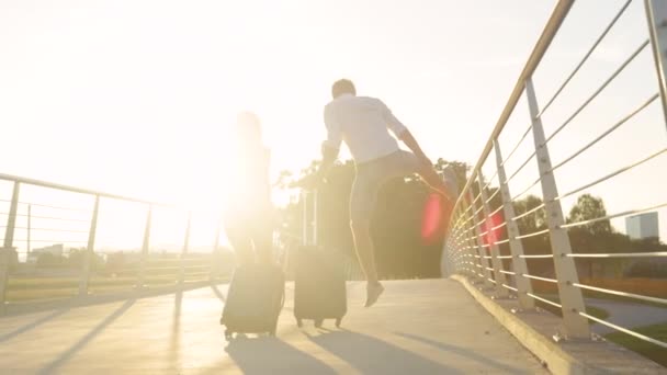 Man en zijn vriendin vieren dat ze op zonnige avond op vakantie gaan.. — Stockvideo