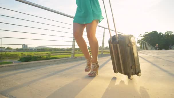 ÁNGULO BAJO: Mujer feliz gira con su maleta mientras camina hacia el aeropuerto . — Vídeos de Stock