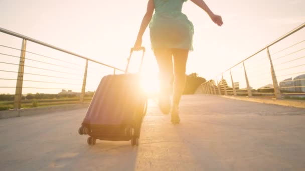 LOW ANGLE: Young woman in heels runs with her luggage to reach airport on time. — Stock Video