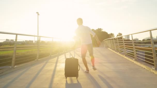 LENS FLARE: Aufgeregter Mann knipst bei Sonnenuntergang auf dem Weg zum Flughafen. — Stockvideo