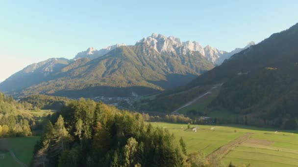 DRONE: Vista panorámica de pastos vacíos bajo una imponente montaña en Eslovenia . — Vídeo de stock