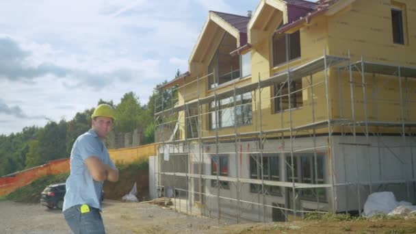 COPY SPACE: Гордый подрядчик бросает свою каску в воздух перед новым домом — стоковое видео