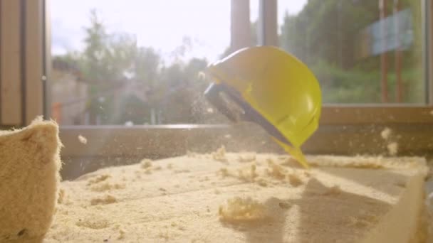 CLOSE UP, DOF : Le casque de sécurité du constructeur s'écrase sur un coussin de mousse isolante. — Video