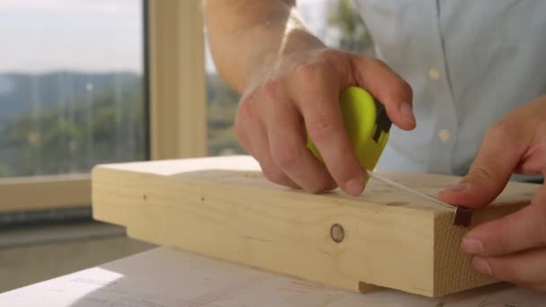 Tanımlanamayan adam bir tahta parçasını incelemek için mezura kullanıyor.. — Stok video