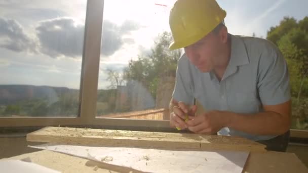 FERMETURE : L'entrepreneur jette une planche sur le banc et la mesure avec du ruban à mesurer — Video