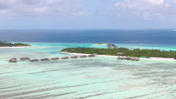 DRONE: Vista panoramica di un'isola esotica e cottage in legno fronte mare di fascia alta. — Video Stock