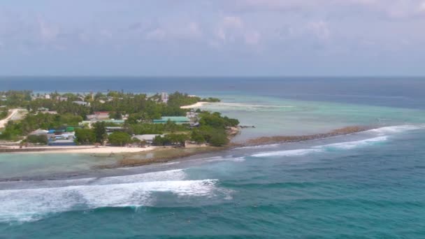 AERIAL: Volando cerca de una isla exótica escénica mientras los surfistas nadan hasta la línea . — Vídeos de Stock