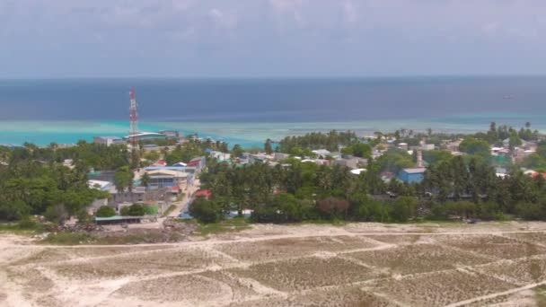 AERIAL: Voando acima de uma aldeia tranquila na remota ilha tropical nas Maldivas . — Vídeo de Stock