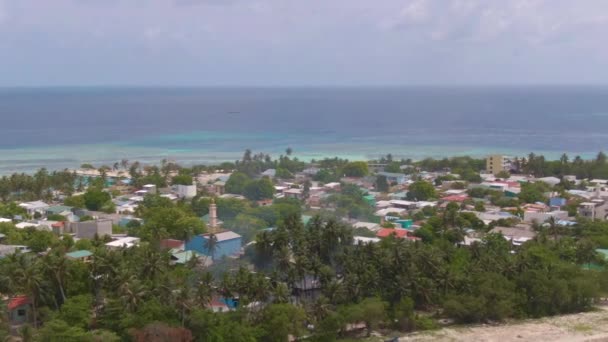 DRONE: Vista aérea panorámica de una pequeña ciudad en una ubicación remota en las Maldivas. — Vídeos de Stock