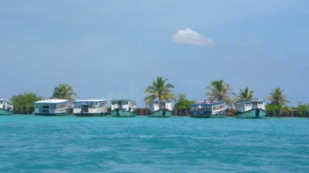 LOW MOTION: Vista idílica de uma frota de barcos atracados por uma ilha tropical . — Vídeo de Stock