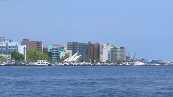 MOVIMIENTO Lento: Barcos y yates están anclados en la costa de una isla modernizada — Vídeo de stock