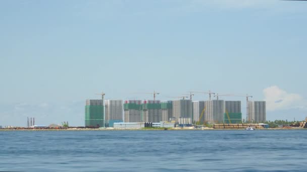 スローモーション:エキゾチックな島の海岸沿いに建設中のクレーンが塔を取り囲みます — ストック動画