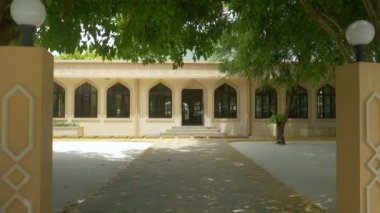 Rüzgarda sallanan ağaçlar bir caminin boş avlusunda esiyor.