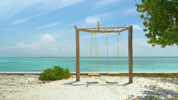 FECHAR UP: Balanço de madeira vazio na praia de areia branca com vista para o oceano sem fim — Vídeo de Stock