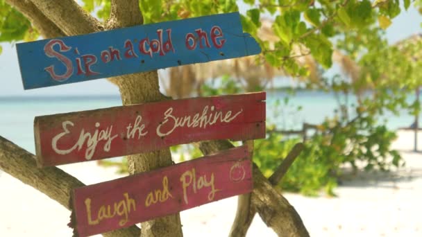 CLOSE UP: Vintage signs tell tourists to enjoy their day on the tropical beach — Stock Video