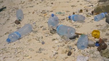 Plastik şişeler Himmafushi 'deki kumlu sahile saçılmış.