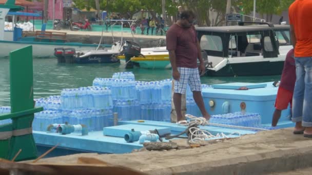 SLOW MOTION: Einheimische auf den Malediven stapeln Wasserflaschenpakete auf kleinen Booten — Stockvideo