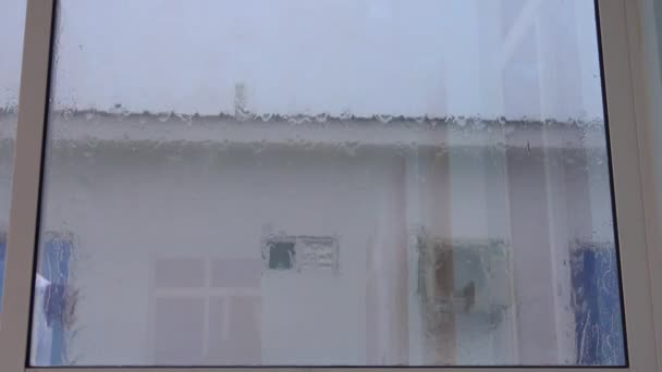 FECHAR-SE: Gotas de chuva descem por uma grande janela de quarto de hotel durante uma tempestade . — Vídeo de Stock