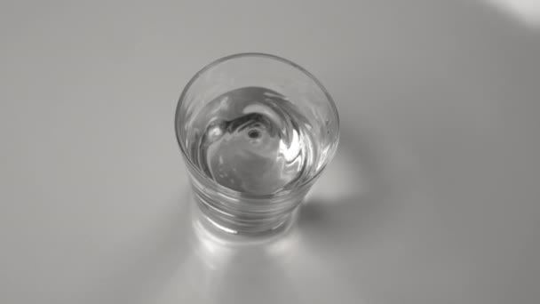 CLOSE UP: Water in een transparant glas wordt gemorst tijdens een aardbeving. — Stockvideo