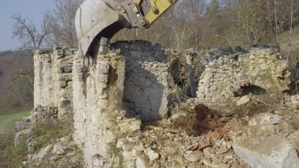 CLOSE UP: Excavator spoon down the old brick wall of a decaying house. — стоковое видео