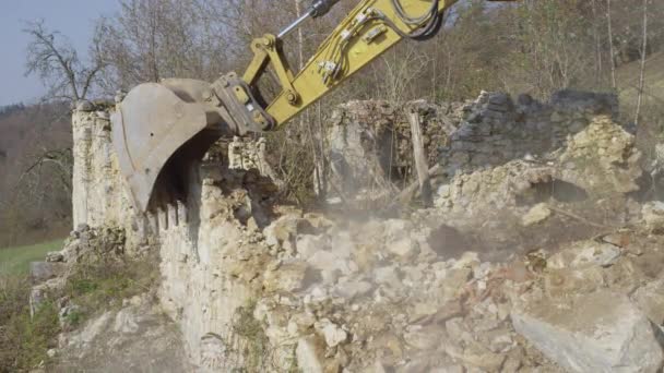 CLOSE UP: Zware industriële graver schept een lepel bakstenen en puin — Stockvideo