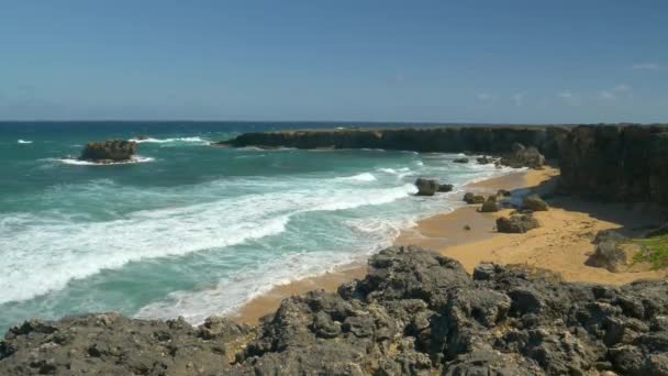 SLOW MOTION: skummande havsvågor tvätta den lilla sandviken omgiven av klippor — Stockvideo