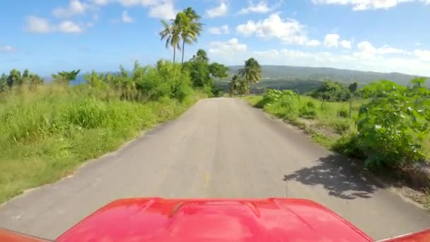 POV: Jeep rojo conduce a lo largo de camino rural vacío corriendo a través de la soleada Barbados . — Vídeos de Stock