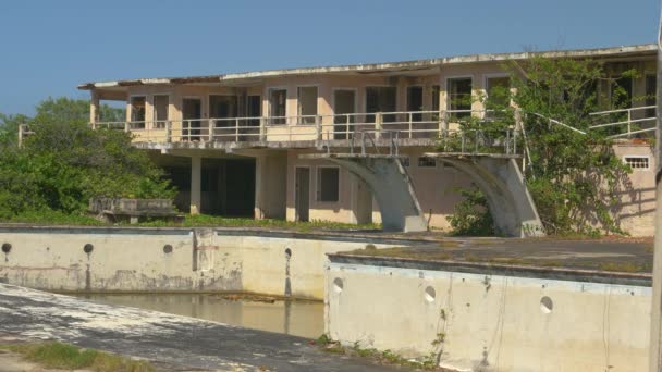 Opuszczony hotel i basen rozkładają się w upale na idyllicznym Karaibach. — Wideo stockowe