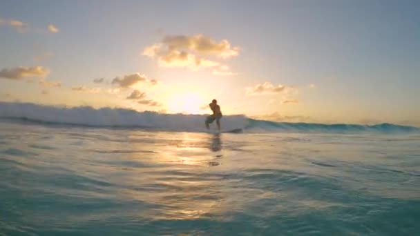 SLOW MOTION: Cinematic skott av en glad surfare rider en liten våg till kusten. — Stockvideo