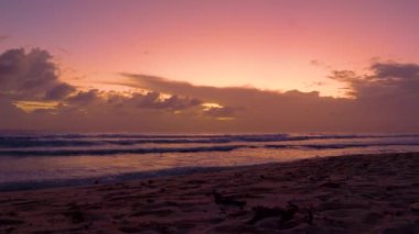 Yanmış turuncu bulutlu gökyüzü, Barbados 'un okyanus kıyılarını yıkıyor.