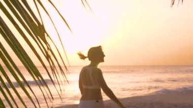 Neşeli turistler, kumsalı keşfederken kollarını açarak dönüyorlar..