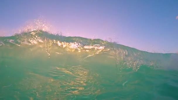 AGUA SUPERIOR: Ola cristalina del océano rompiendo sobre la cámara al atardecer dorado . — Vídeo de stock